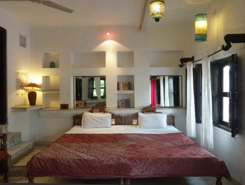 a bedroom with a large bed with a red blanket at Inn Seventh Heaven in Pushkar