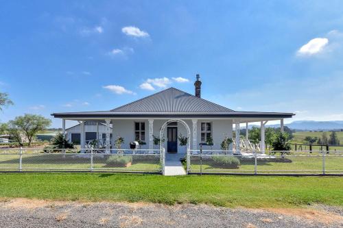 a white house with a fence in front of it at Stellaview Estate in Mitchells Flat
