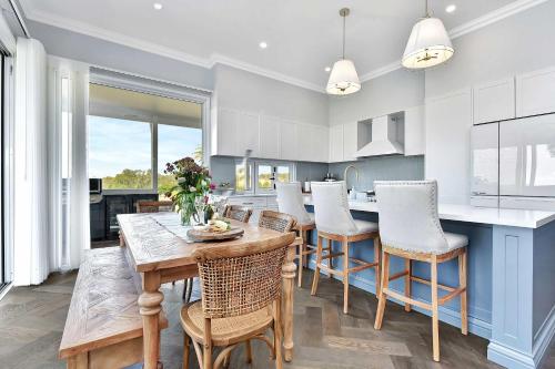 a kitchen with a wooden table and chairs and a counter at Stellaview Estate in Mitchells Flat