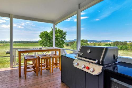 a kitchen with a grill and a table with chairs at Stellaview Estate in Mitchells Flat