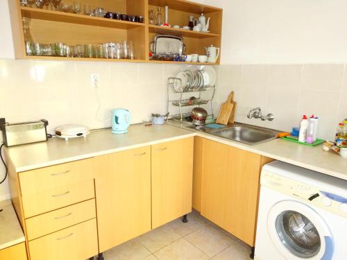 a small kitchen with a sink and a washing machine at Hris in Chernomorets