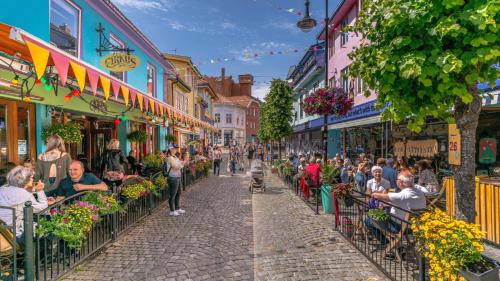 a crowd of people sitting in chairs on a street with buildings at A Place To Stay Stavanger, apartment 6 in Stavanger