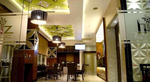 マナドにあるBiz Boulevard Hotelのダイニングルーム(テーブル、椅子、照明付)