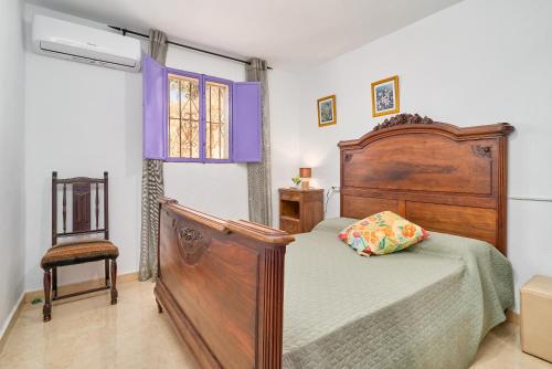 un dormitorio con una cama y una silla en Casa Papi, en Alcaucín