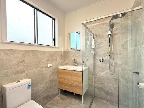 a bathroom with a shower and a toilet and a sink at Beachside Cabin No 2 at Island Beach in Island Beach