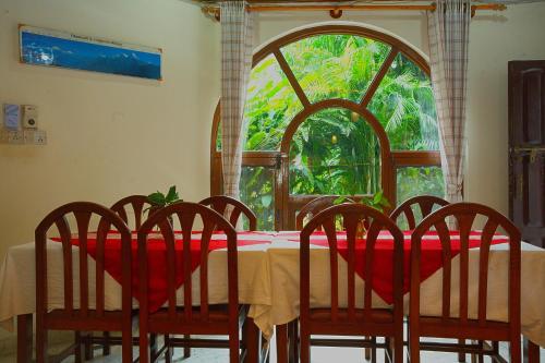 PokharaにあるHotel Lake Palaceのダイニングルーム(テーブル、椅子、窓付)