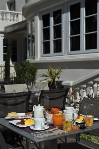 a table with breakfast food on it on a patio at Mercure Paris Saint Cloud Hippodrome in Saint-Cloud