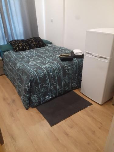a bedroom with a bed and a refrigerator at Espaço Realeza in London