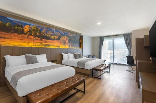 Una habitación de hotel con dos camas y un cuadro en la pared. en The Valor, an Ascend Collection Hotel, en Parowan