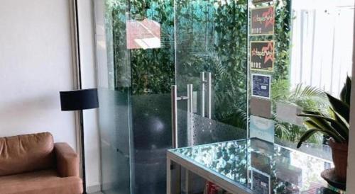 un soggiorno con un tavolo di vetro e un divano di Power Hotel a Kampong Sungai Gelugor