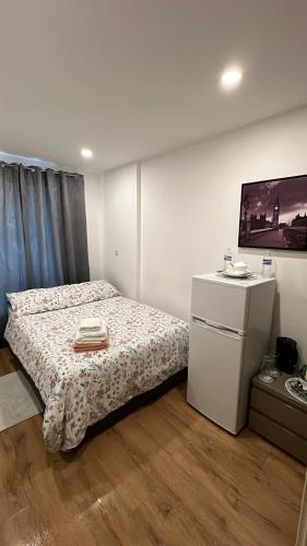a bedroom with a bed and a tv on a wall at Espaço Realeza in London