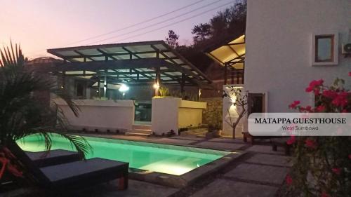 a house with a swimming pool in front of a building at Matappa Guest House in Pulau Sarang