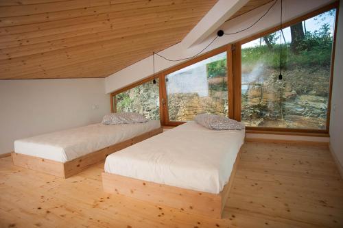 2 Betten in einem Zimmer mit einem großen Fenster in der Unterkunft Apartment Oton Reya in Dobrovo