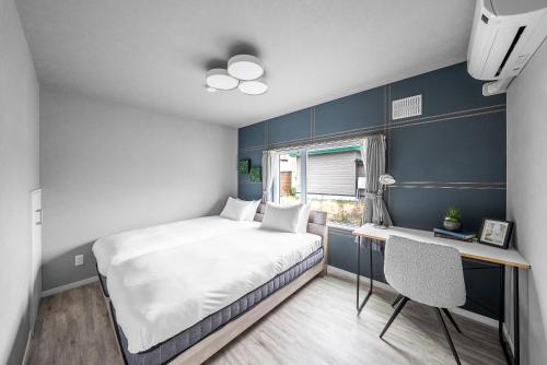 une petite chambre avec un lit, un bureau et une fenêtre dans l'établissement Sasameyuki, à Furano