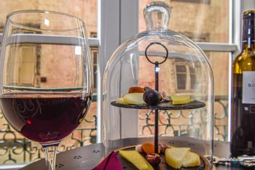 a glass of wine next to a bottle of wine and cheese at B in B Douradores in Lisbon