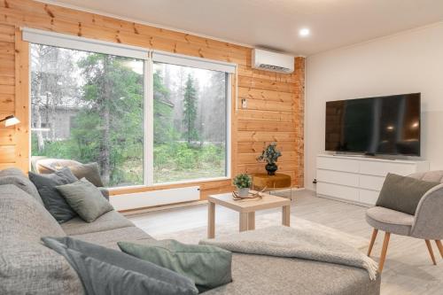ein Wohnzimmer mit Couch und großem Fenster in der Unterkunft Premium 2BR Villa in Ruka with Private Sauna & Free Parking in Ruka