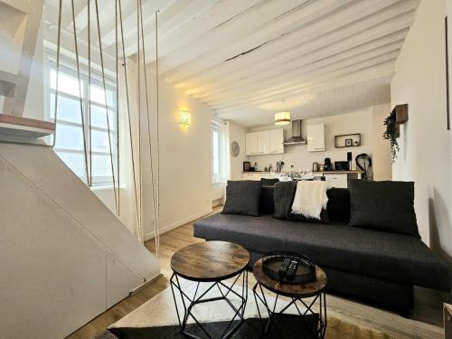 una sala de estar con un sofá y una mesa en Perchoir Riboud - Coeur de ville, en Bourg-en-Bresse