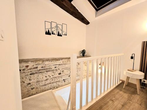 una escalera blanca en una casa con una pared de piedra en Perchoir Riboud - Coeur de ville, en Bourg-en-Bresse