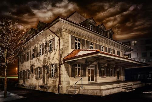 an old building is lit up at night at Boutique Hotel Spedition a member of DESIGN HOTELS in Thun