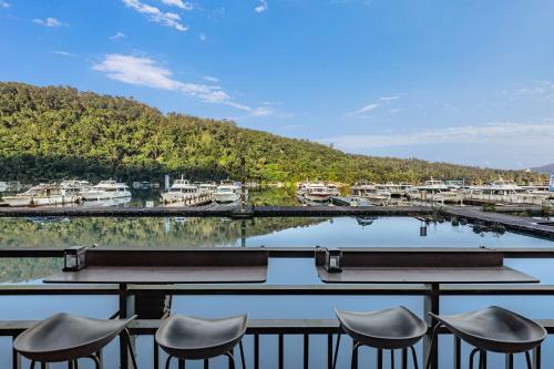a group of chairs sitting on a balcony overlooking a marina at Shui Yang Lakeview House with Elevator in Yuchi