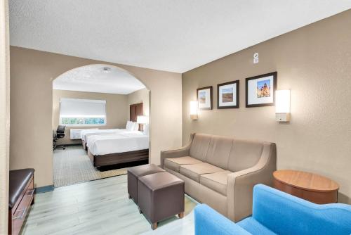 レイクウッドにあるComfort Suites Lakewood - Denverのベッドとソファのあるホテルの部屋