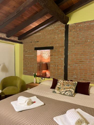 a bedroom with a bed and a brick wall at Beit Shalom, Casa Rural in Hervás