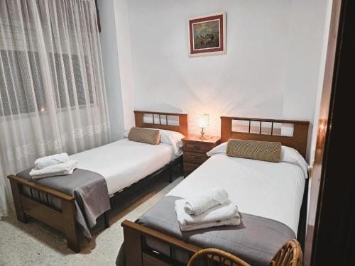 two beds in a room with towels on them at Casa de Pueblo con Encanto in Valderrubio