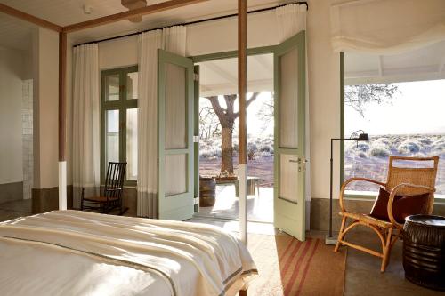 ein Schlafzimmer mit einem Bett und einem großen Fenster in der Unterkunft Noois’hof Sinclair Nature Reserve in Helmeringhausen