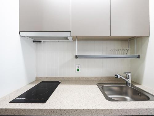 a kitchen with a sink and a counter top at Elmomento Sasang in Busan