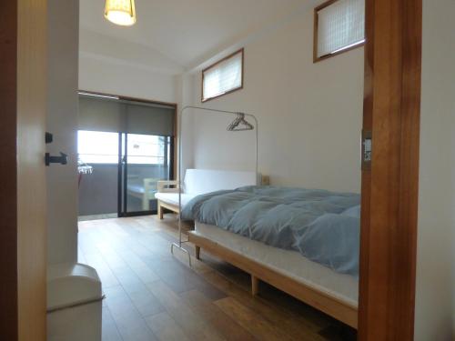 a bedroom with a bed and a window at Guesthouse Hyakumanben Cross in Kyoto