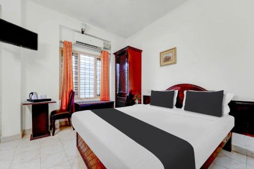 a bedroom with a black and white bed and a window at Super Collection O Chalai Bazaar Near Railway Station Formerly Galaxy Inn in Trivandrum