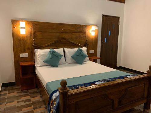 a bedroom with a large bed with a wooden headboard at Ella Nest View Homestay in Ella