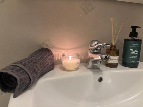 a bathroom sink with a candle and a towel at Cozy apartment in Åmål