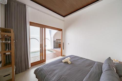 - un ours en peluche assis sur un lit dans une chambre dans l'établissement Il Petrucino Villa, à Nusa Dua