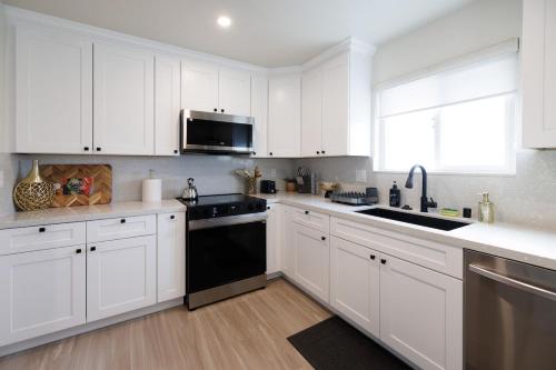 eine weiße Küche mit weißen Schränken und einem schwarzen Geschirrspüler in der Unterkunft Upscale Bay Area themed place near Santana Row in San Jose
