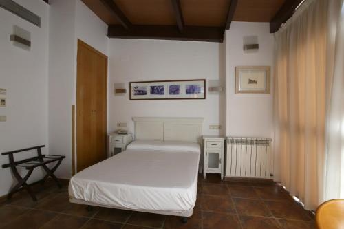 アビラにあるHotel Las Murallasの白いベッドと窓のある寝室