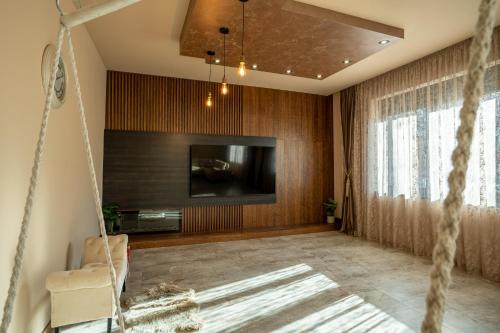 a living room with a tv on a wall at Zsizell Lux Apartman in Kanjiža