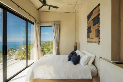 Un dormitorio con una cama y una ventana grande en RAKSA Villas, en Ban Madua Wan