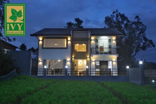 a house lit up at night with lights on it at Ivy Bungalow in Nuwara Eliya