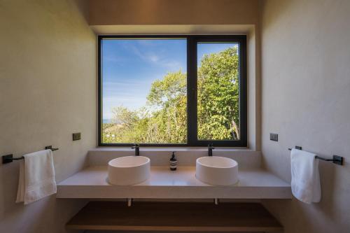 Dos lavabos en un baño con una gran ventana. en RAKSA Villas, en Ban Madua Wan