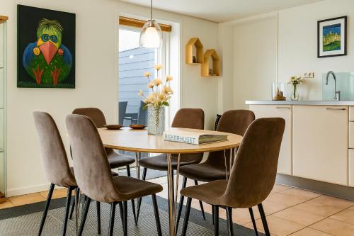 a kitchen and dining room with a wooden table and chairs at Fiskerhuset i Øster Hurup - i byen, ved stranden in Øster Hurup