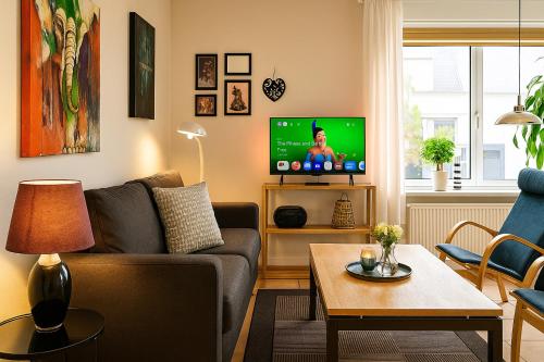 a living room with a couch and a tv at Fiskerhuset i Øster Hurup - i byen, ved stranden in Øster Hurup