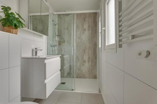 HaarleにあるLuxe vakantiewoning Hellendoorn Sallandse Heuvelrug nmr 36のシャワーと洗面台を備えた白いバスルーム