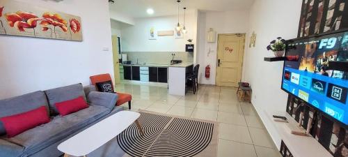 a living room with a couch and a kitchen at Rich Return Empire in Gua Sai