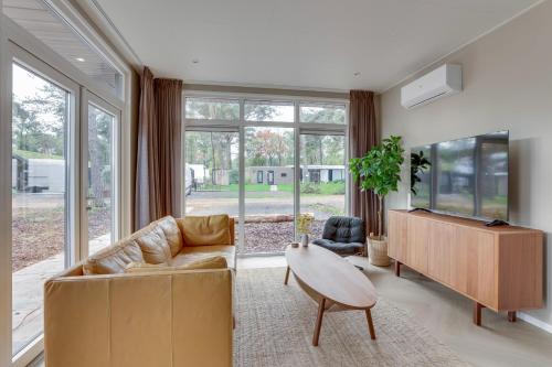 una sala de estar con un sofá y una mesa en Natuurhuisje Hellendoorn met luxe Hottub, en Haarle