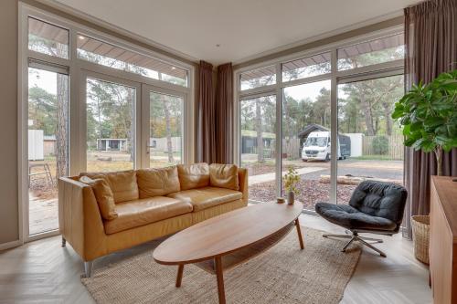 Una sala de estar con un sofá y una mesa de café. en Natuurhuisje Hellendoorn met luxe Hottub, en Haarle