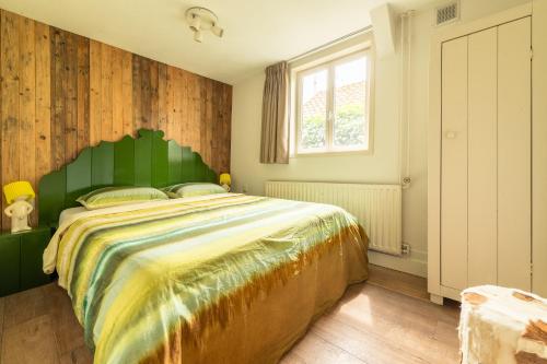 une chambre avec un grand lit avec une tête de lit verte dans l'établissement Holiday home Landelijk Amsterdam, à Amsterdam