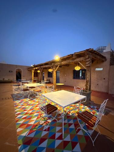 ザゴラにあるLa Petite Kasbahのカラフルなフロアのパティオ(テーブル、椅子付)