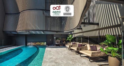 a hotel lobby with a swimming pool and chairs at Best Western Ratchada Hotel in Bangkok