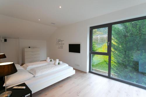 a white bedroom with a bed and a window at Villa Shangrila - Alpstay in Naturno